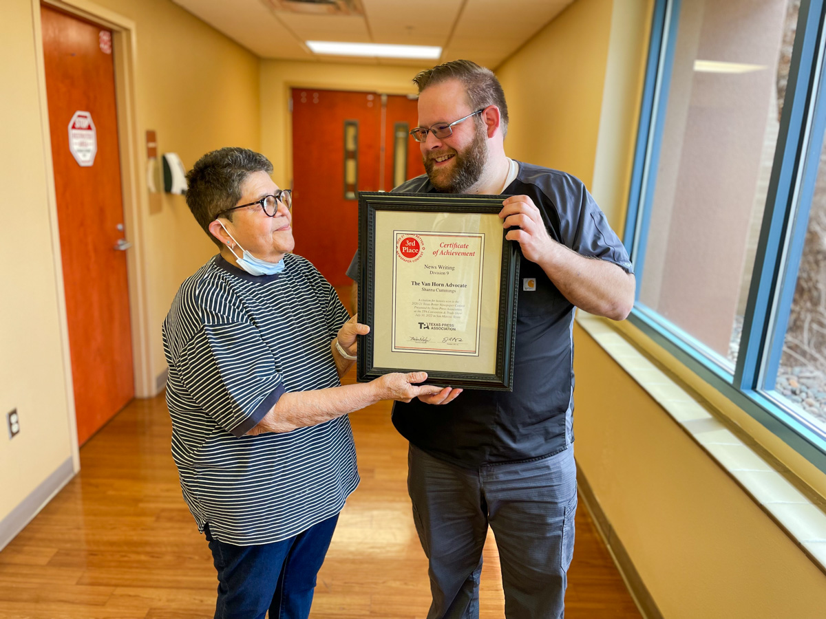 Advocate Editor Gilda Morales presented her colleague Dr. David Cummings with a certificate of achievement from the 2020-2021 Texas Better Newspaper Contest won by his late wife, Shanna. Shanna was also recognized by her peers for Headline Writing for her article titled Bumps and Bonds.